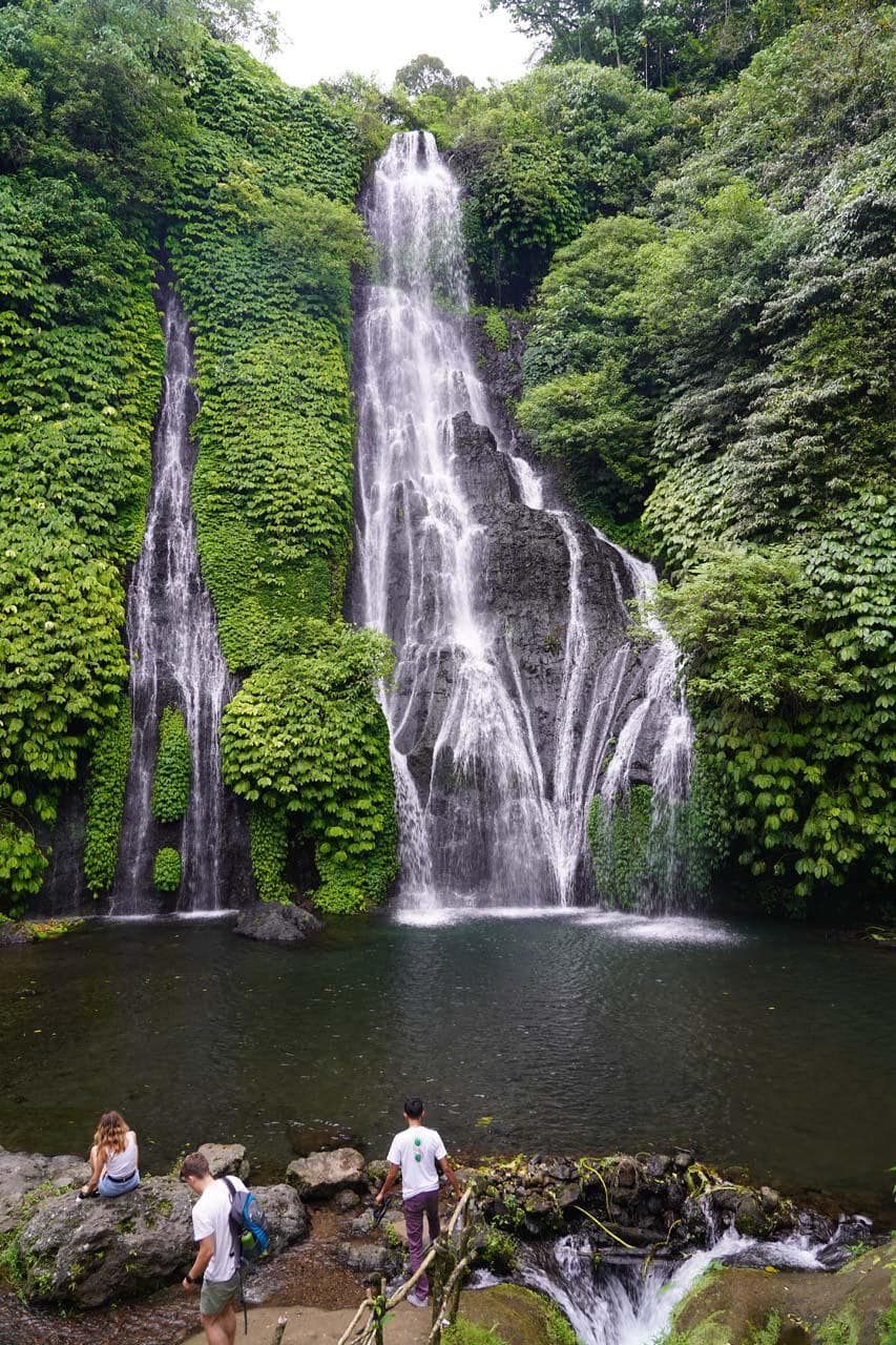 Visitors at the pool beneath the twin cascades of Banyumala Waterfall