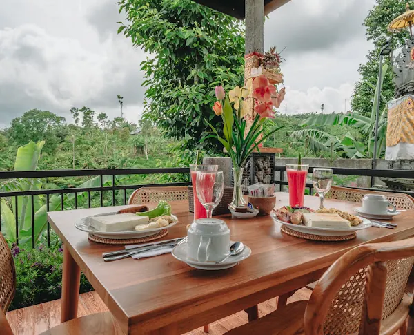 Breakfast table set with toast, fruit, juice and coffee, overlooking the garden and hills